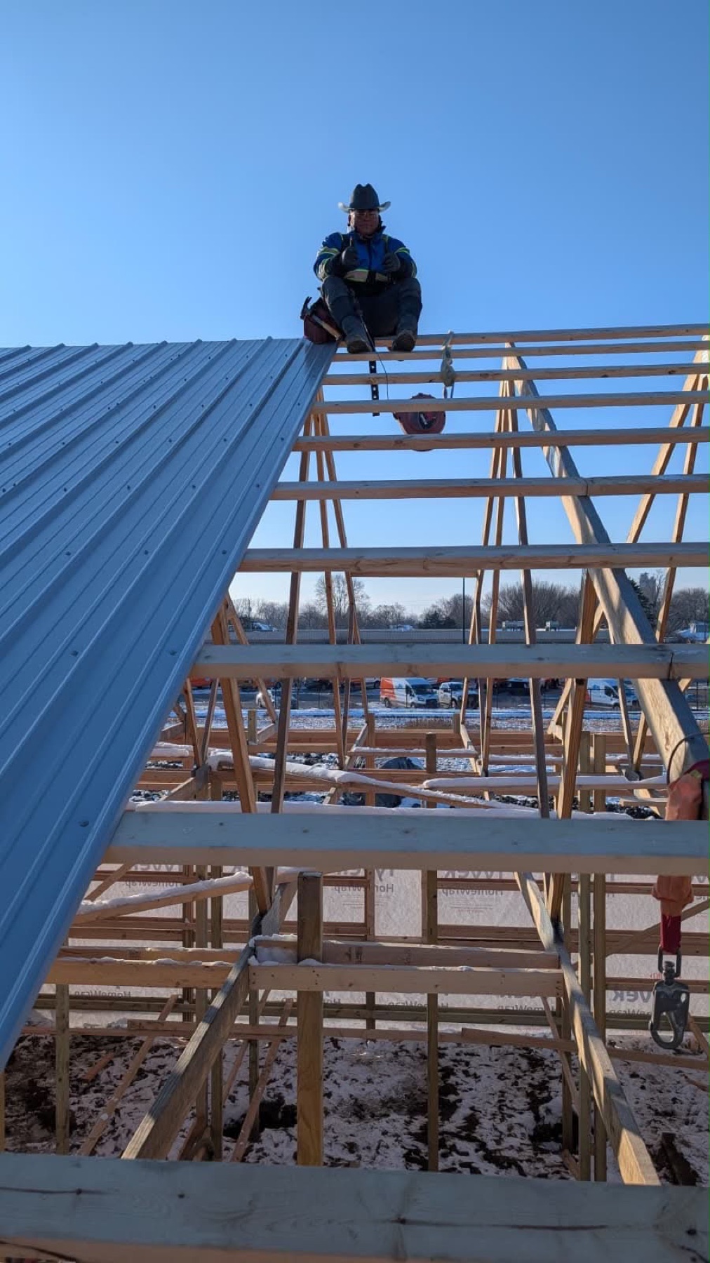 Crew installing a standing-seam metal roof on a new build