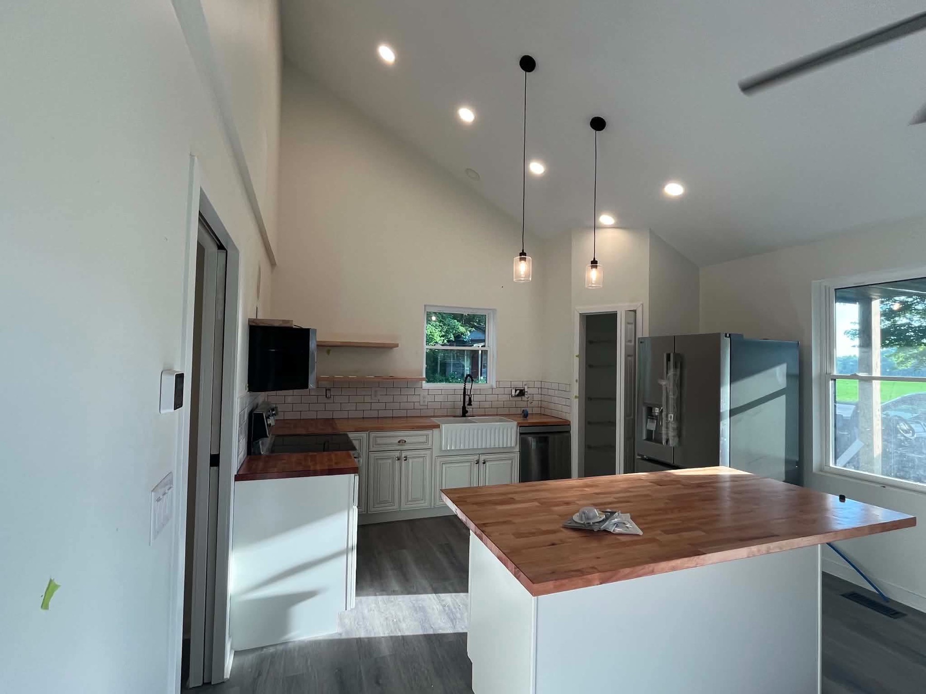 Finished kitchen with island, wood countertop and recessed lighting